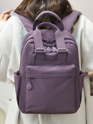 Purple mini Oxford cloth backpack with front pocket and side pockets.