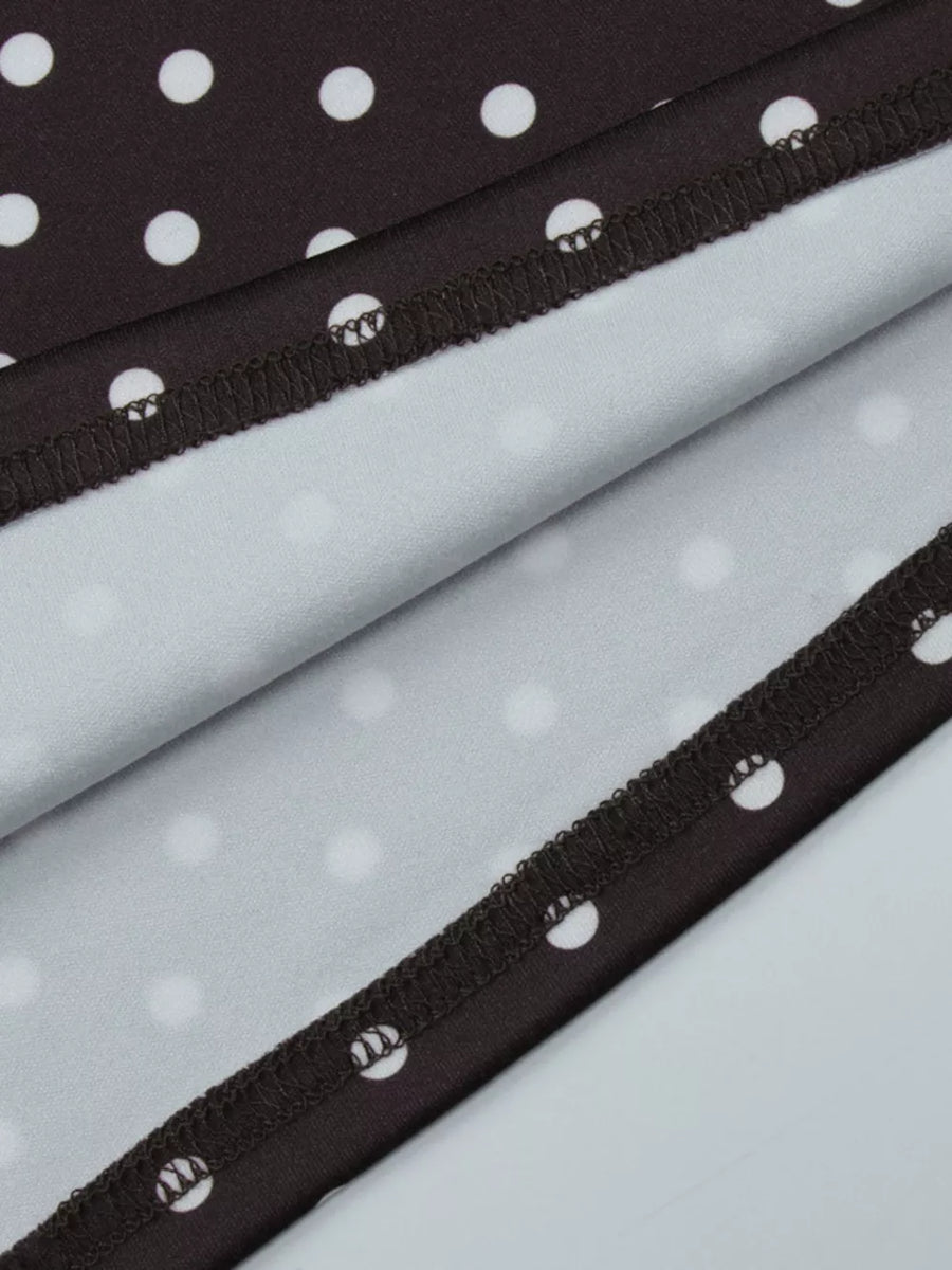 Brown polka dot mini dress detail showing hem with white polka dots on brown fabric.