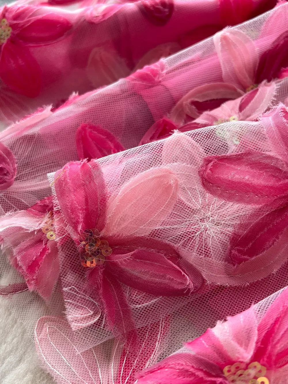 Layered tulle skirt with embroidered floral appliques and sequins in shades of pink.