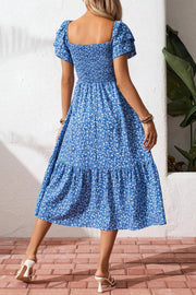 Blue floral smocked square neck dress with tiered skirt and short puff sleeves.