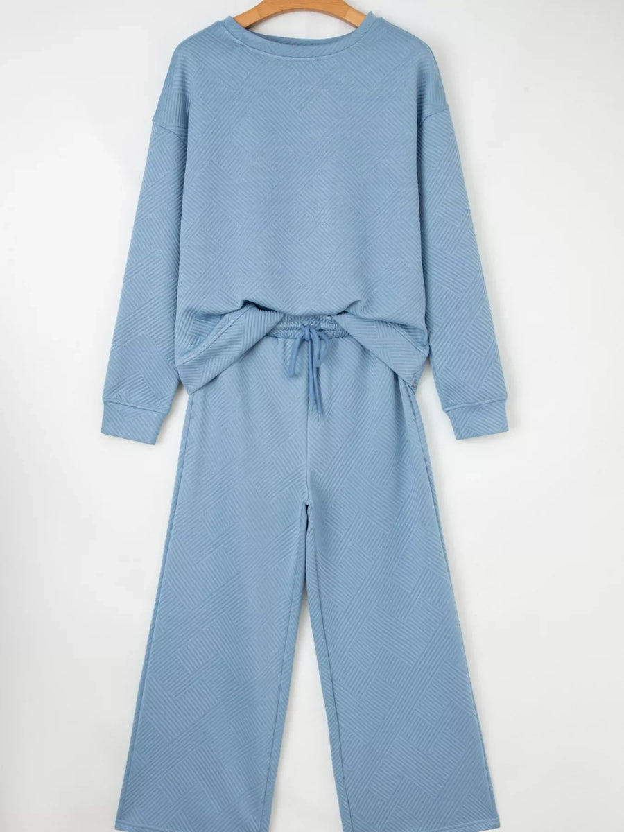 Textured light blue drawstring two-piece set with wide leg pants and crewneck sweatshirt.