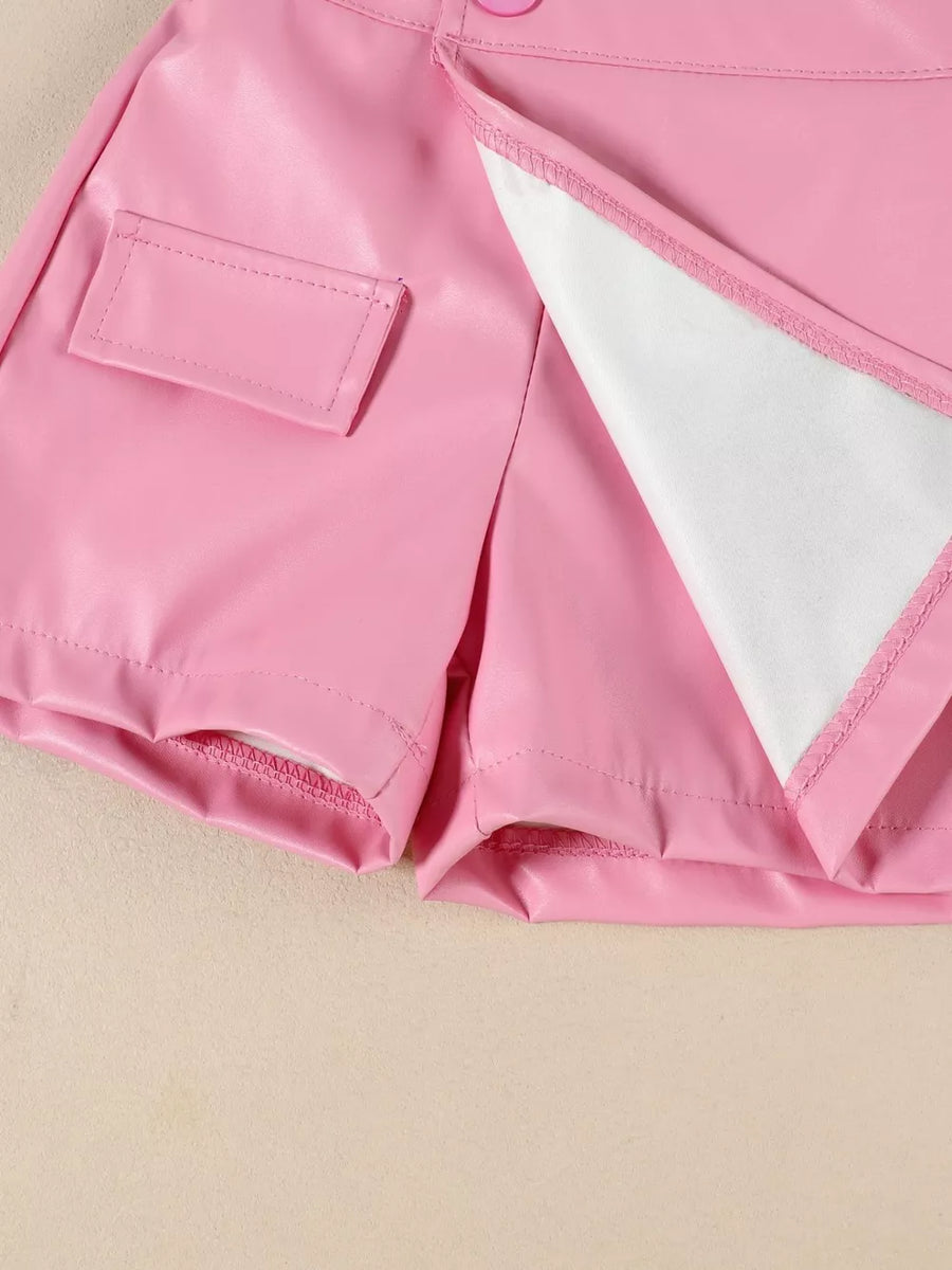 Pink faux leather skort with decorative pocket and button detail.