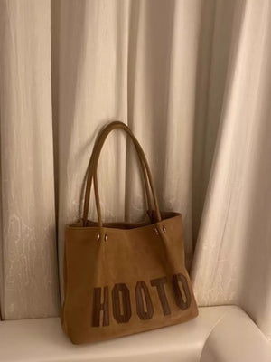Brown PU leather tote bag with embossed lettering and double straps.