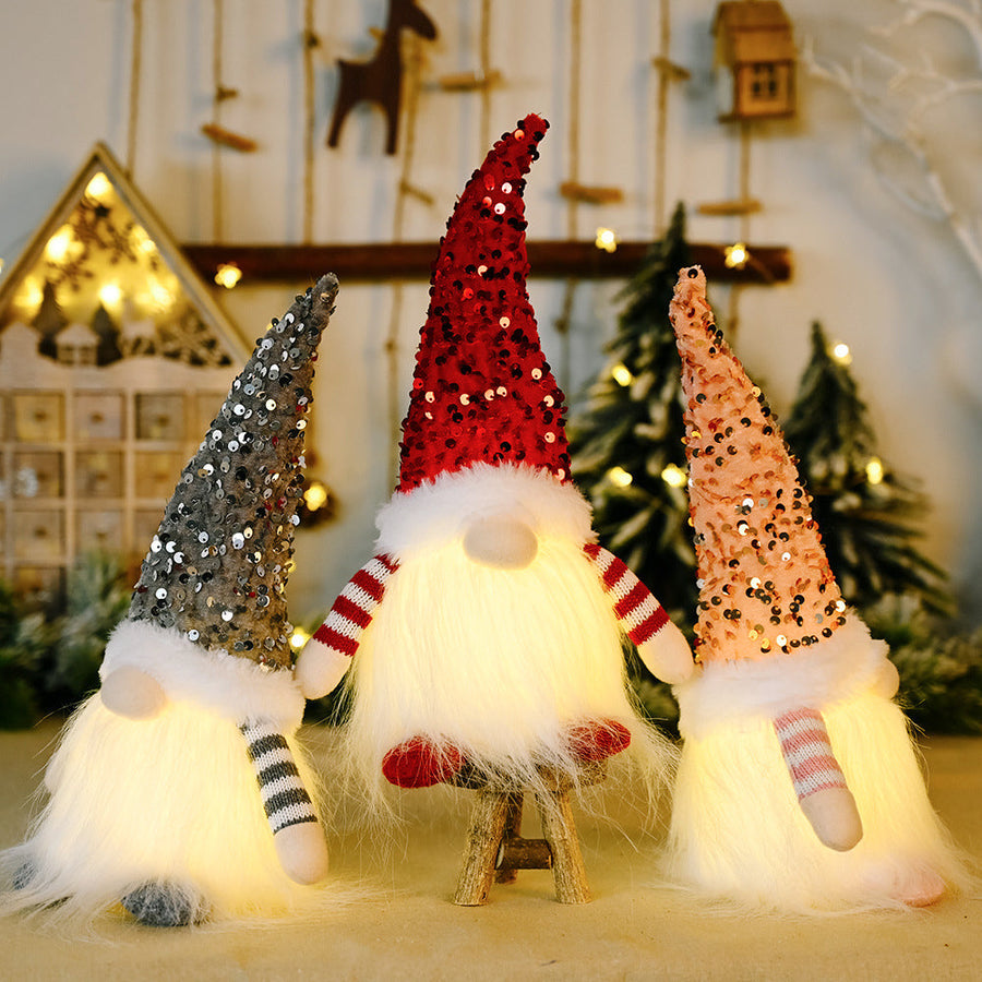 Light-Up Sequin Gnome Trio in dark gray, red, and blush pink with fluffy bodies and striped sleeves.