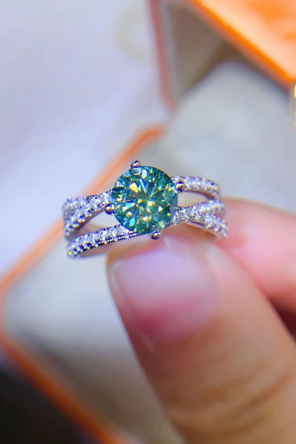 Twisted pavé halo ring with teal stone in 925 sterling silver.