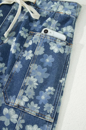 Floral drawstring barrel jeans with pockets in blue denim, featuring a daisy print and a phone in the pocket.