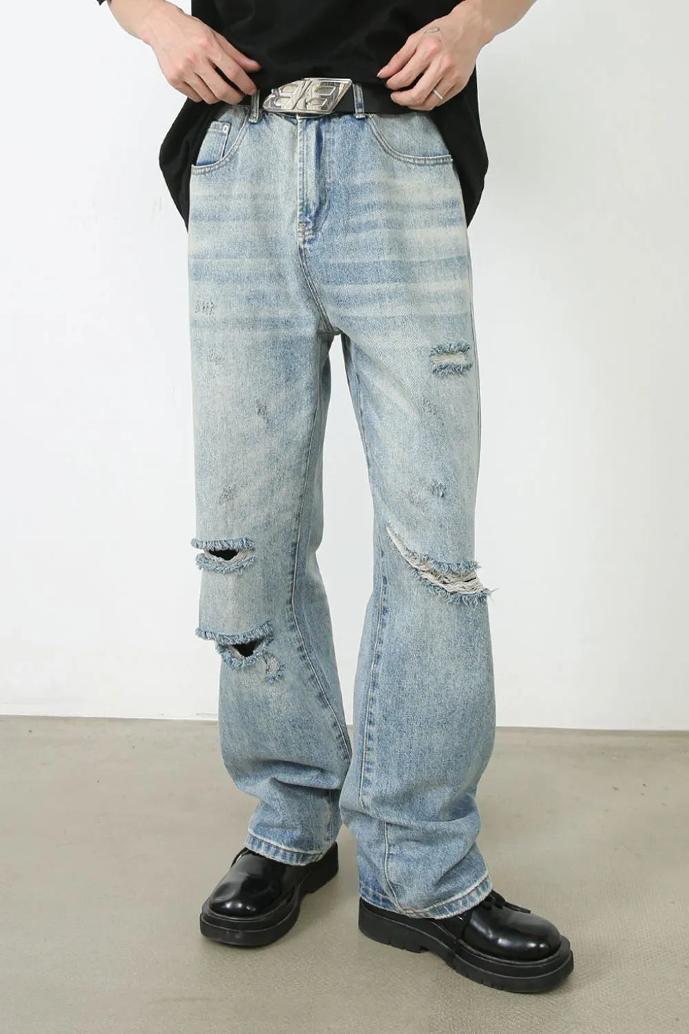 Baggy ripped denim jeans in medium wash with distressed details and a relaxed fit.