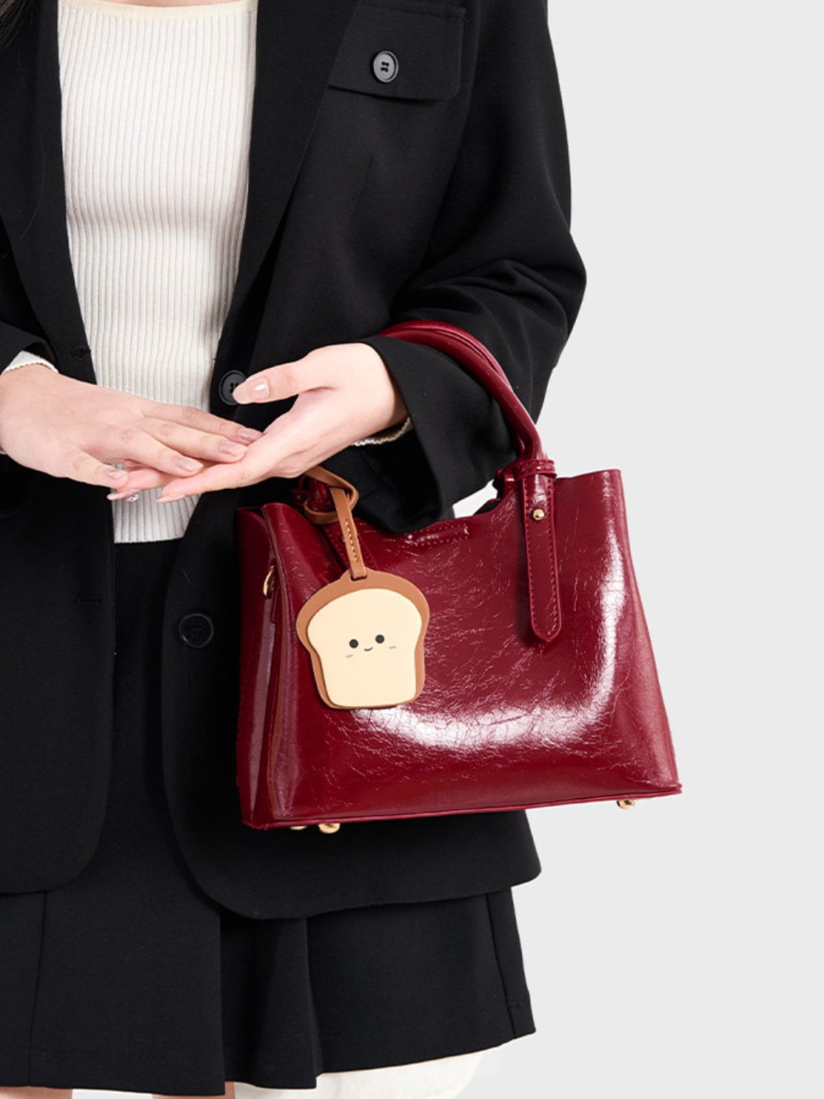 handbag in burgundy featuring top handle and structured fit