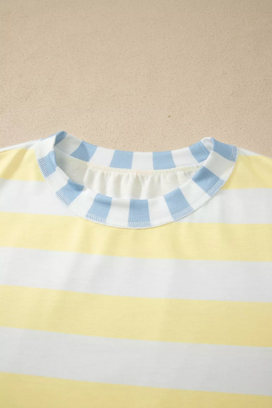 Striped t-shirt in yellow and white with a blue and white striped crew neck.