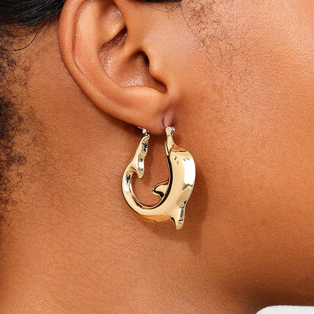 Gold dolphin hoop earrings with a sleek, polished finish.