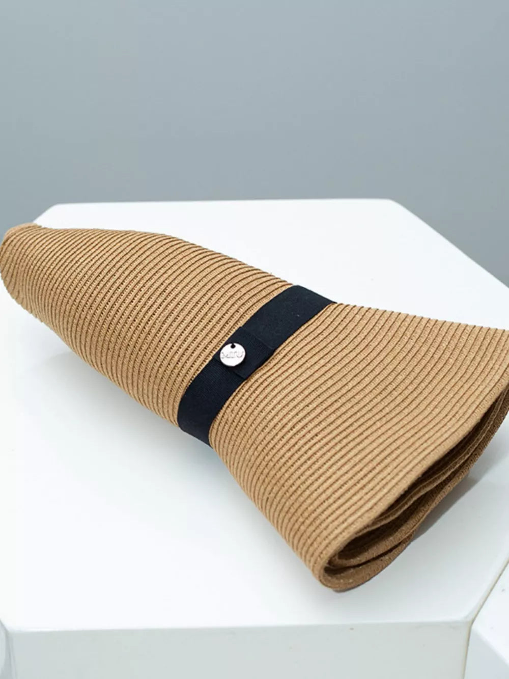 Charming straw sun hat in khaki with elegant black ribbon detail and metal charm.
