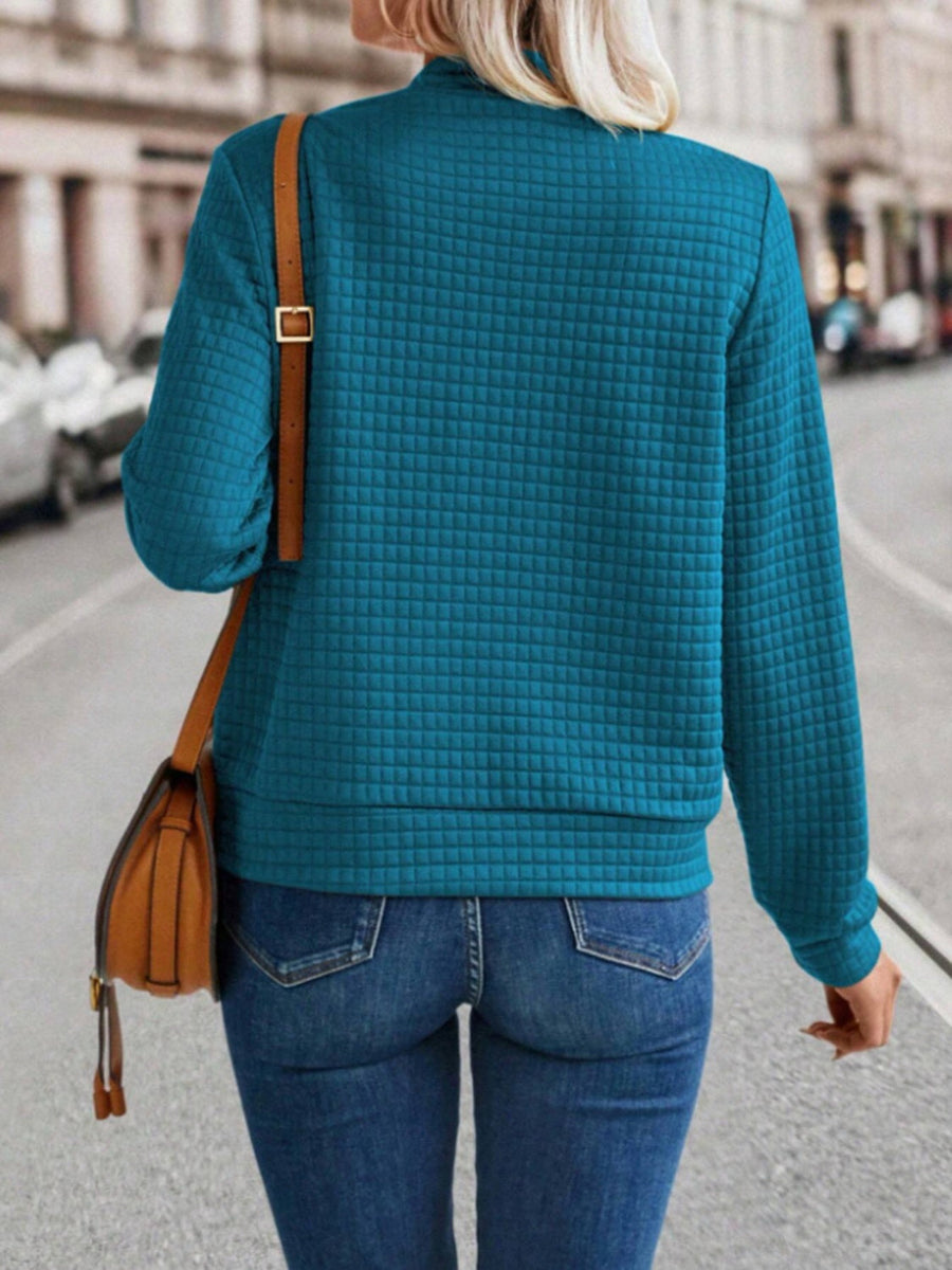 French blue quilted bomber jacket with zip closure, long sleeves, and a stand-up collar.