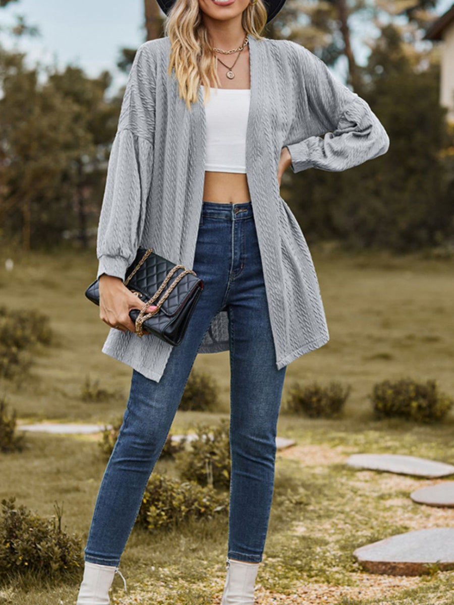 Gray textured open cardigan with balloon sleeves, worn with jeans and a white crop top.