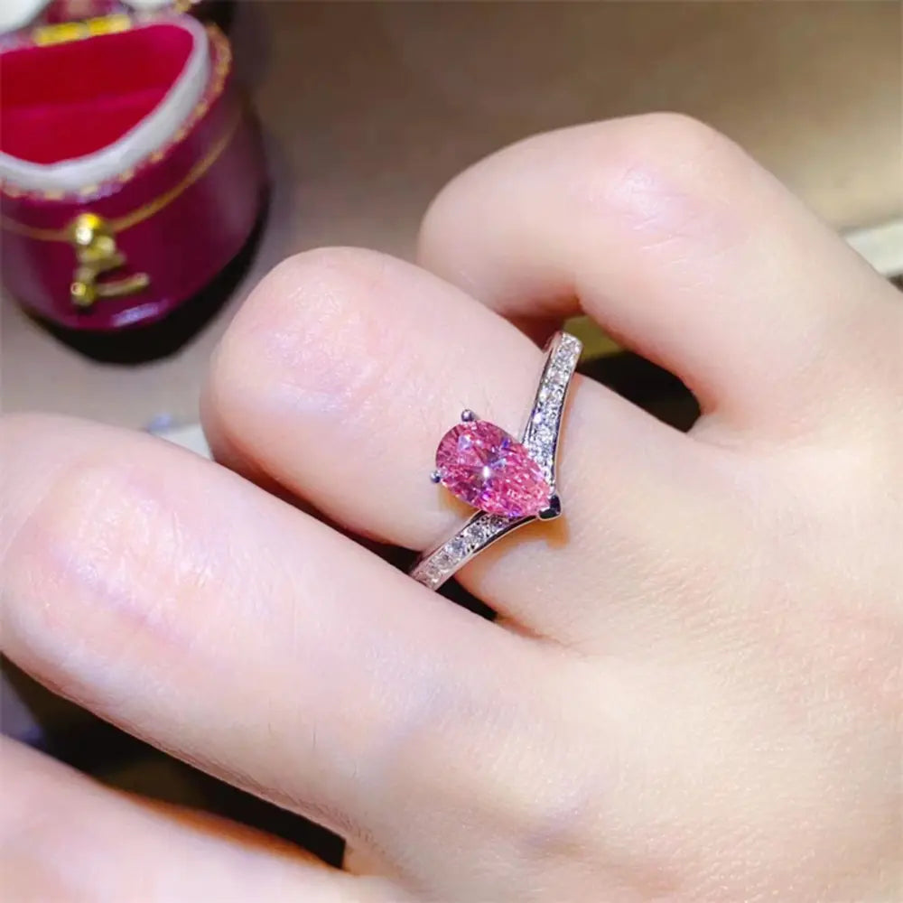 Pink pear-cut moissanite chevron ring in silver with pave diamond band
