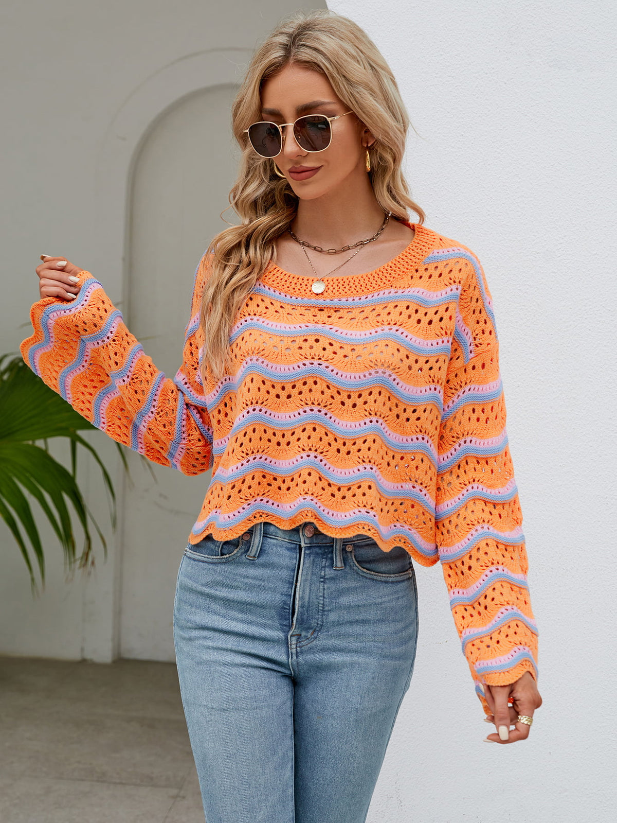 Orange and blue striped crochet crop sweater with scalloped hem and bell sleeves.