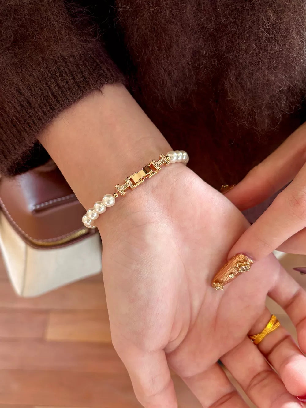 Gold pearl bracelet with H-shaped buckle and zircon accents