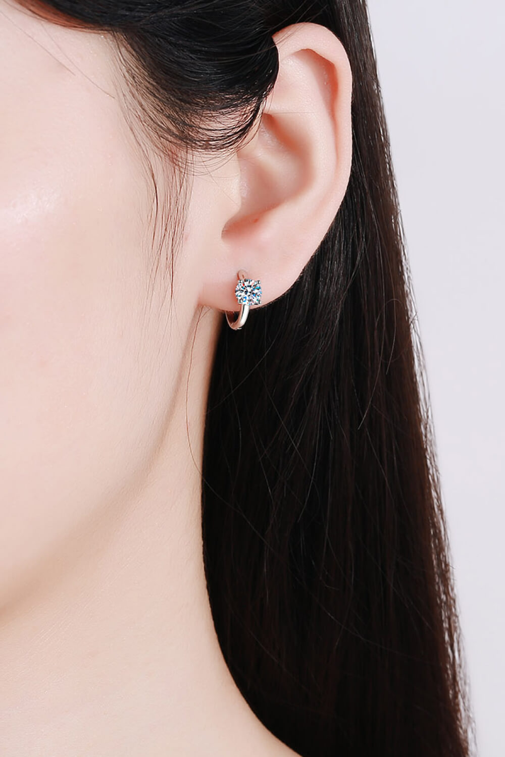 Silver solitaire halo hoop earrings with a single sparkling stone.