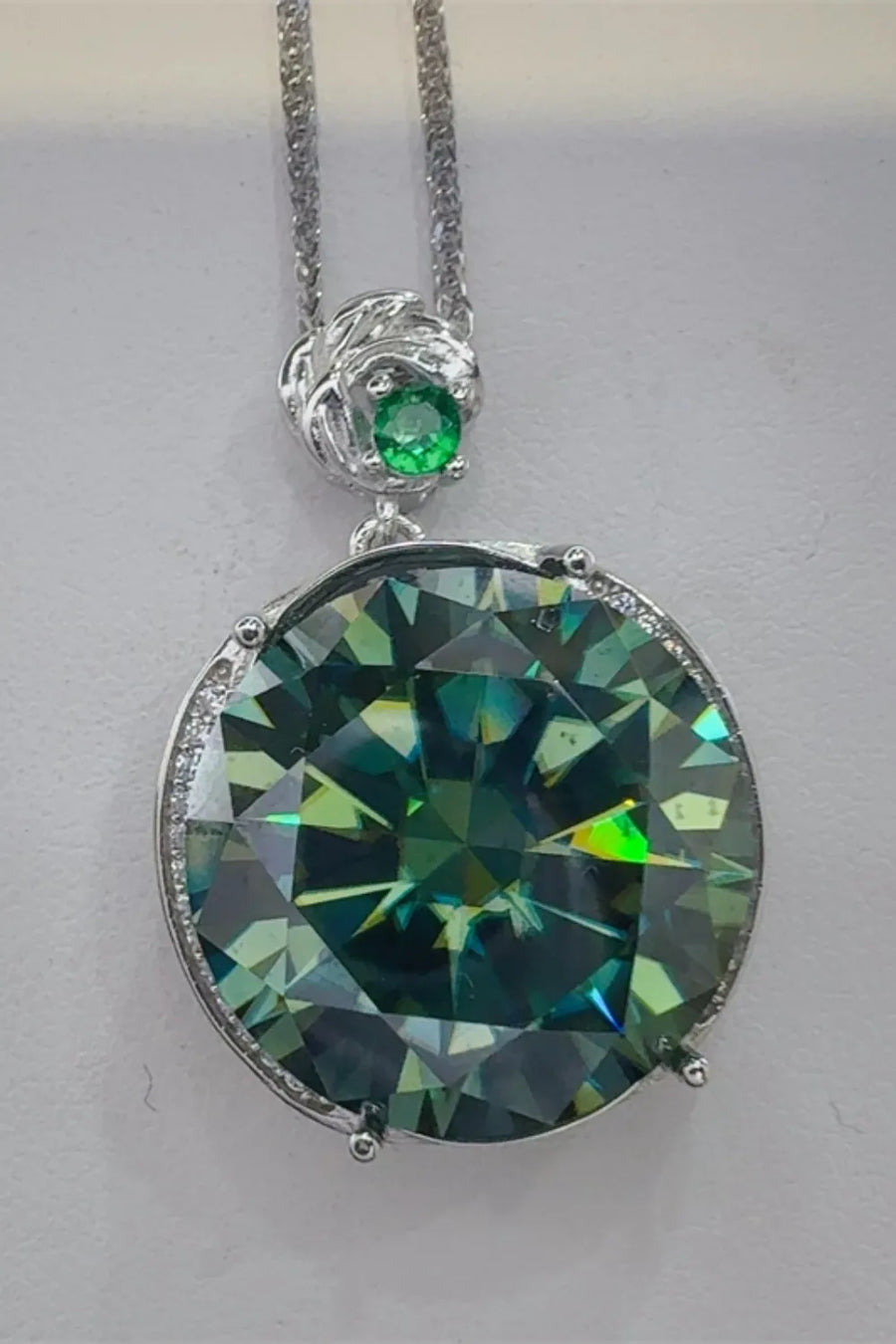 Dark green moissanite and sterling silver necklace with a small emerald accent.