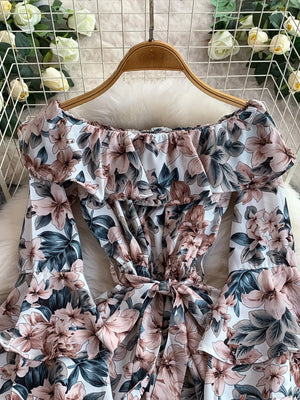 Off-shoulder ruffled romper with floral print, tie waist, and bell sleeves.