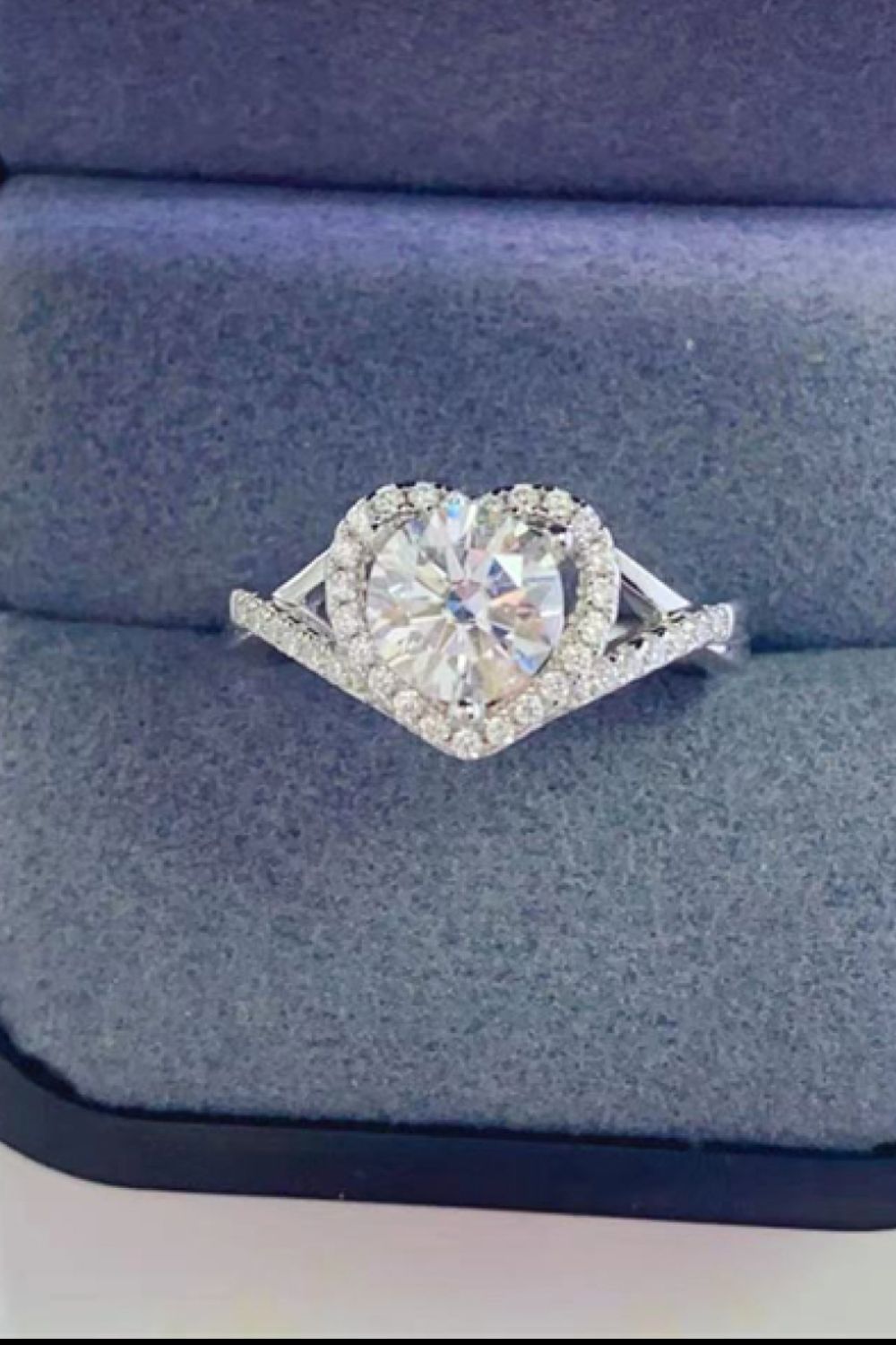 Silver engagement ring with a heart-shaped moissanite center stone and a diamond halo.
