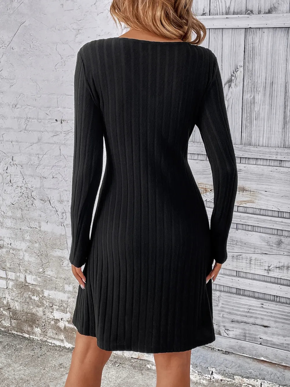 Black mini dress featuring decorative button and ribbed