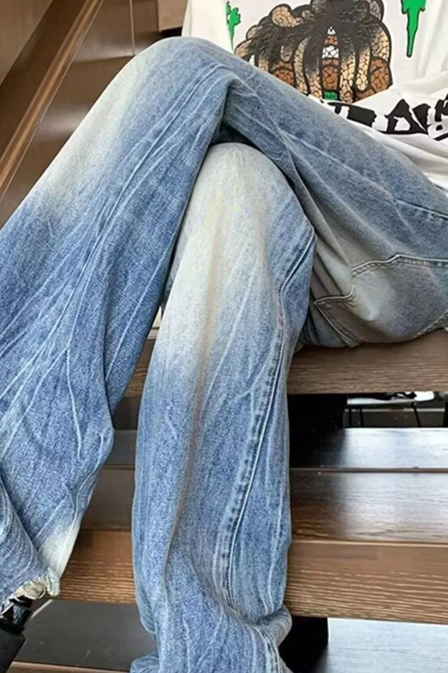 Men's wide-leg jeans with blue ombre wash and distressed details.