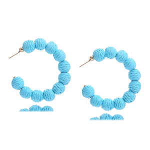 Raffia grass C-hoop earrings in sapphire blue with beaded texture.