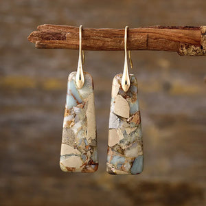 Textured stone drop earrings with gold hooks, featuring natural stone patterns in blue, tan, and brown hues.