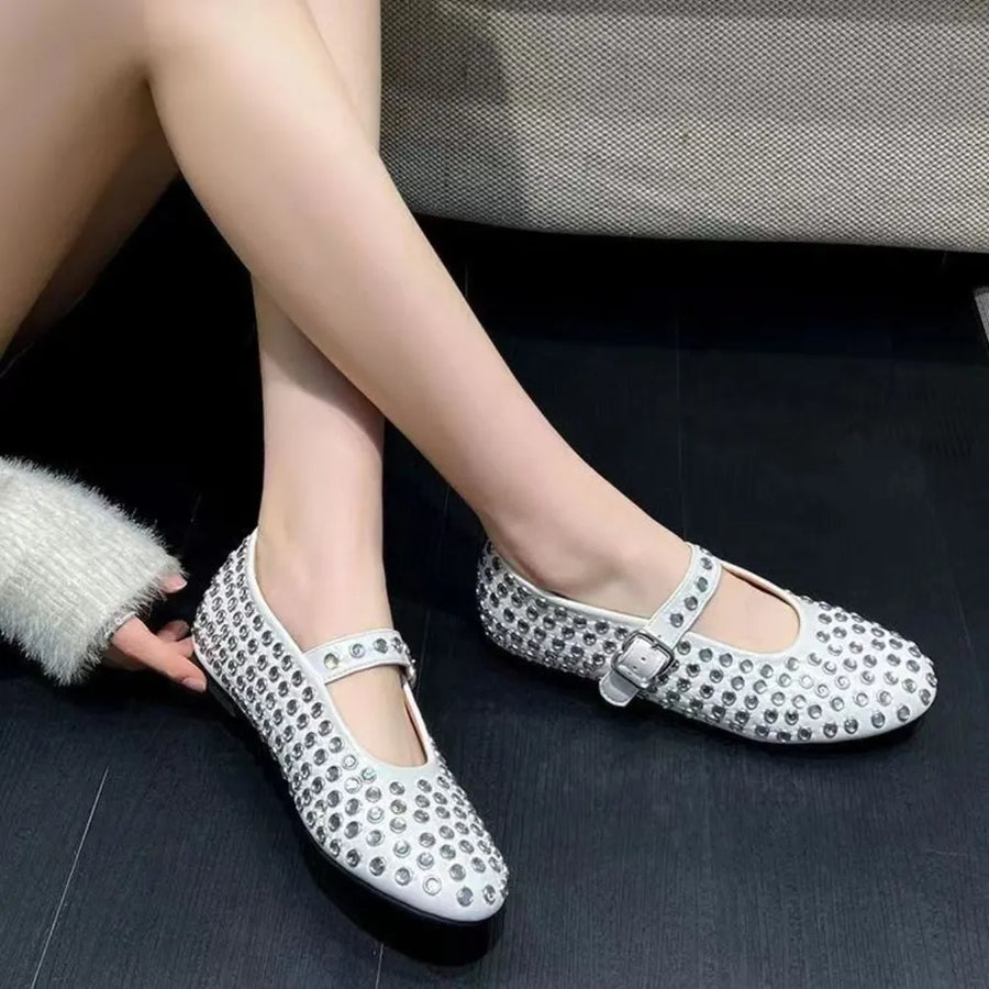 White studded Mary Jane flats with buckle strap detail.
