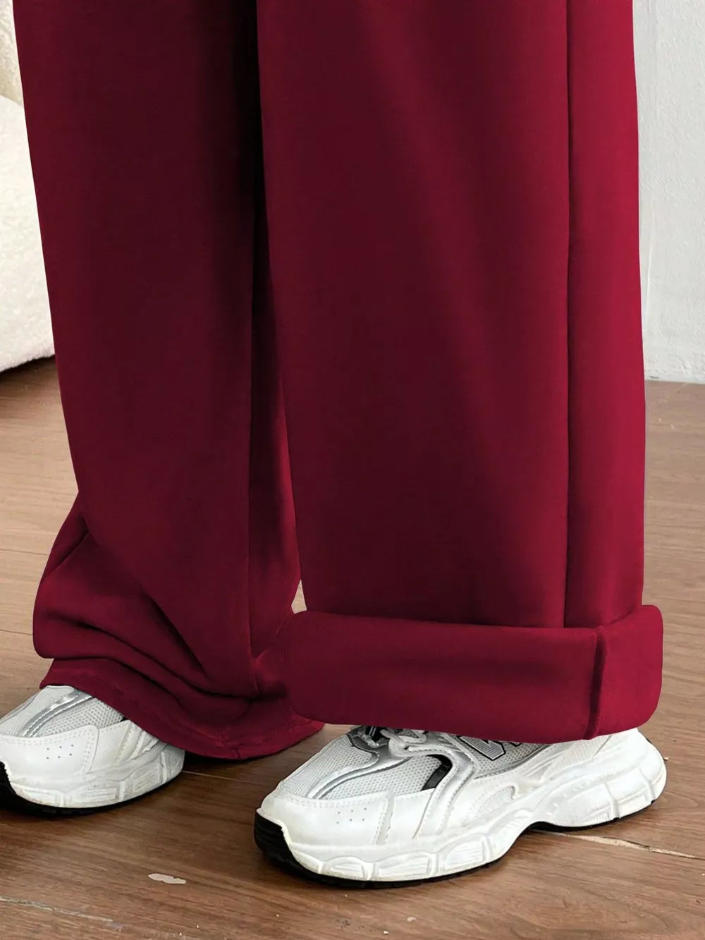 Burgundy wide-leg maternity joggers with cuffed hems, styled with white sneakers.