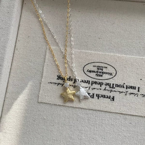gold necklace featuring star pendant and geometric