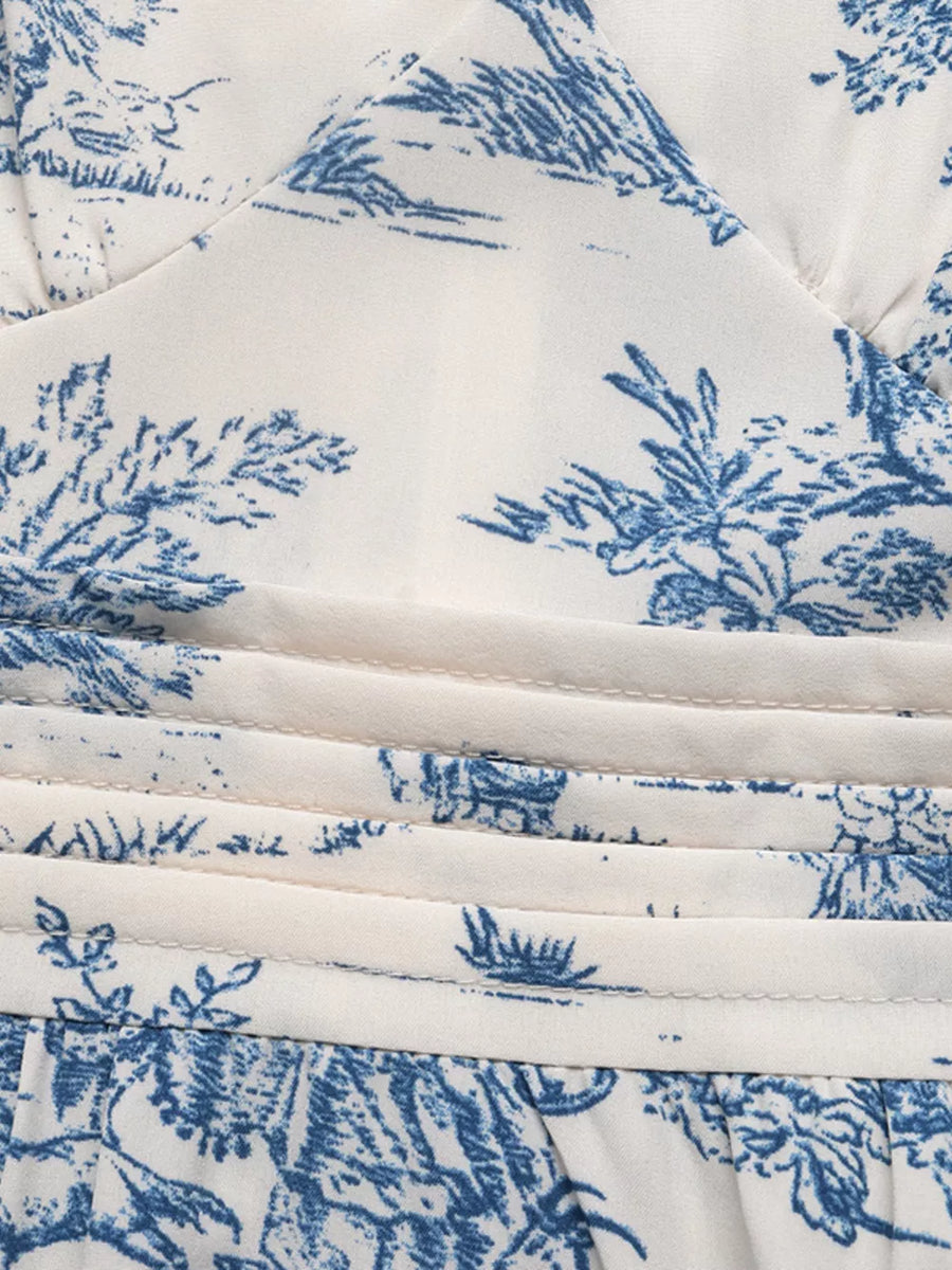 Toile print midi dress with blue scenic pattern, V-neck, and ruched waist detail.