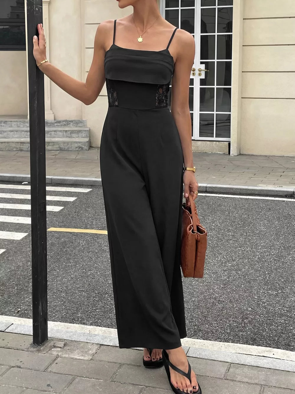 Black lace-trimmed wide-leg maternity romper with spaghetti straps and a square neckline.