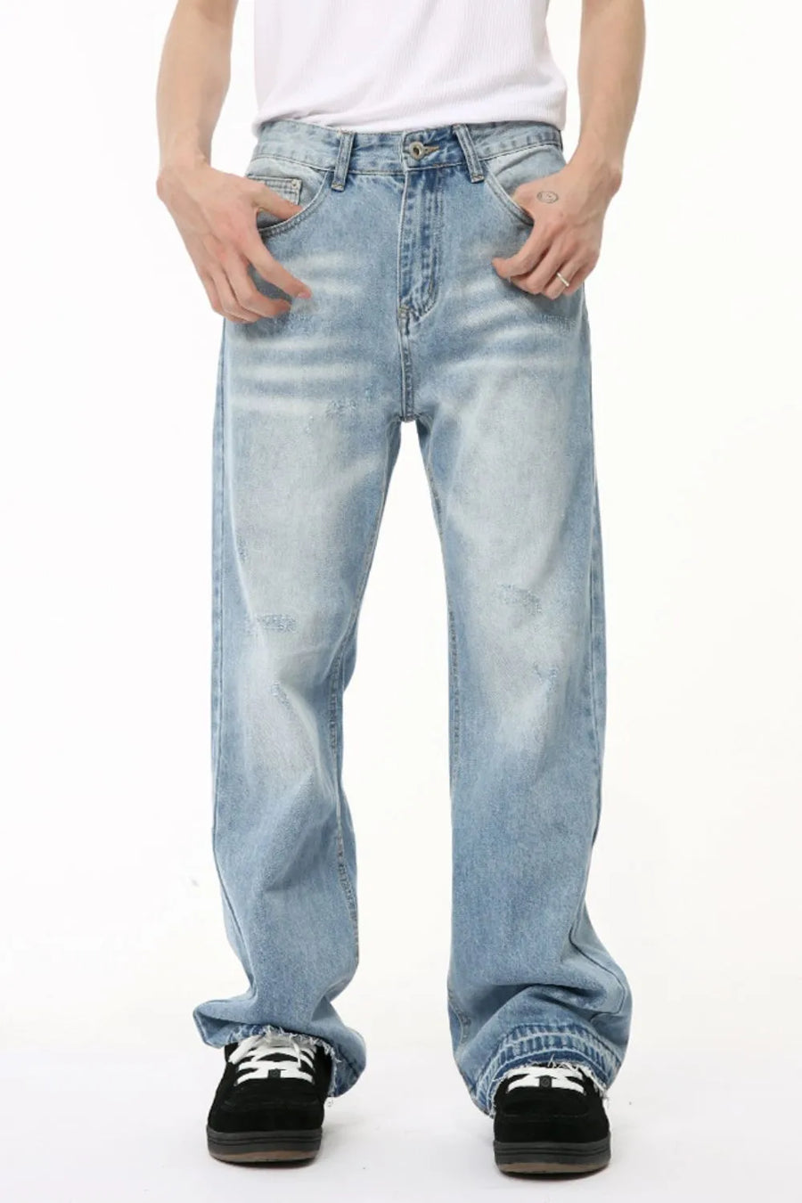 Baggy light wash denim jeans with distressed details and raw hem.
