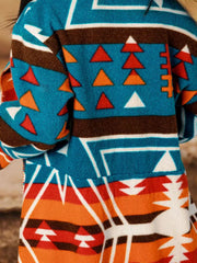 Southwestern print shawl collar jacket in peacock blue with geometric and triangle patterns.