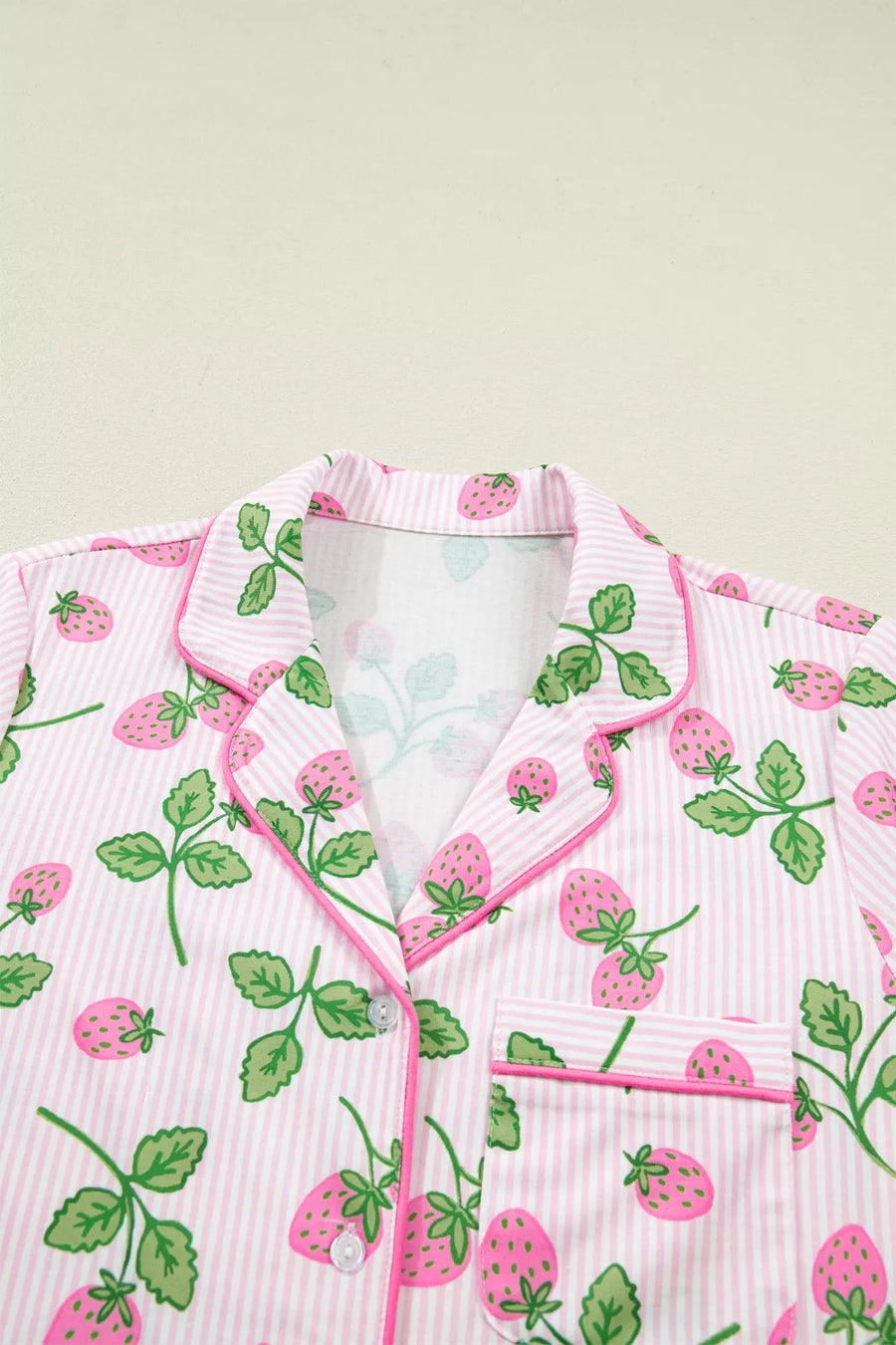 Pink striped pajama top with a whimsical strawberry print, button front, and piped trim.