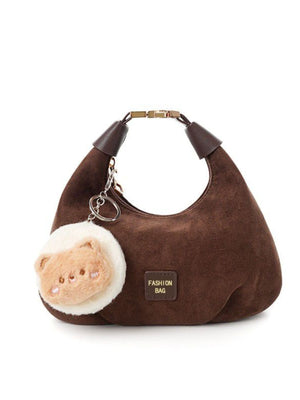 Chocolate crescent shoulder bag with a fluffy bear charm and "FASHION BAG" detail