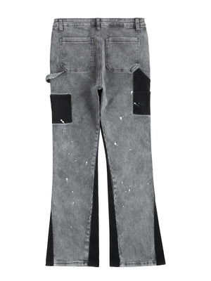 Dark gray bootcut jeans with black panels, paint splatters, and split hem