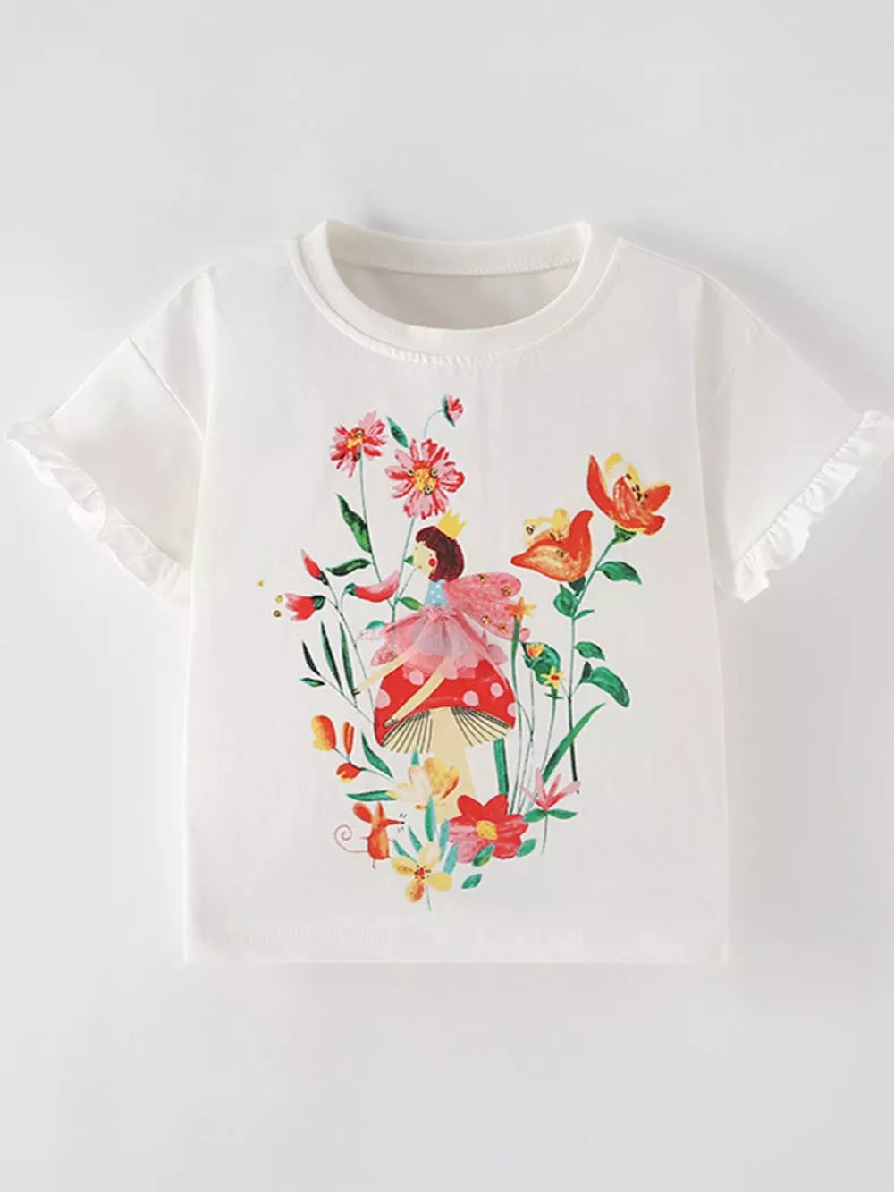 White cotton t-shirt with ruffled sleeves and a whimsical fairy graphic surrounded by colorful flowers.