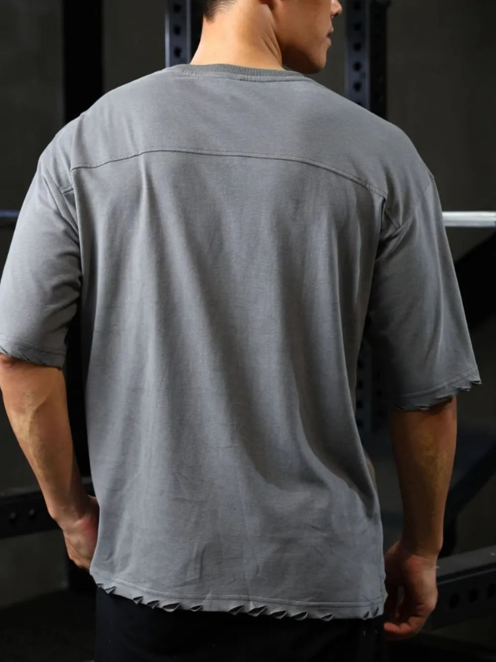 Gray oversized tee with raw edges and a distressed look.