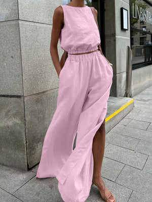 Pink sleeveless crop top and wide-leg pants set with crew neck and side slits.