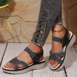 Black woven criss-cross platform sandals with adjustable straps and white trim.