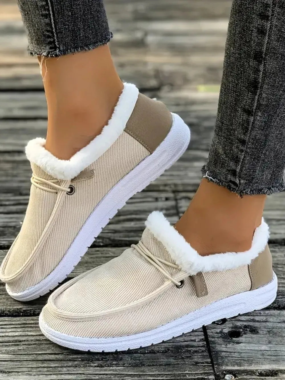 Ivory corduroy slip-on sneakers with sherpa lining and tan heel detail.