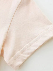 Baby dress sleeve detail in pale pink cotton with double-stitched hem.