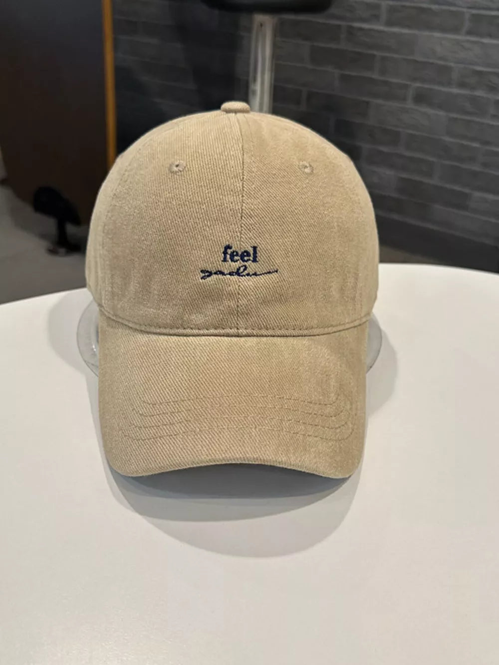 Tan baseball cap with embroidered blue text "feel good