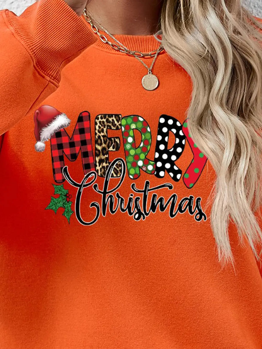 Orange graphic sweatshirt with Merry Christmas text in festive patterns and Santa hat detail.