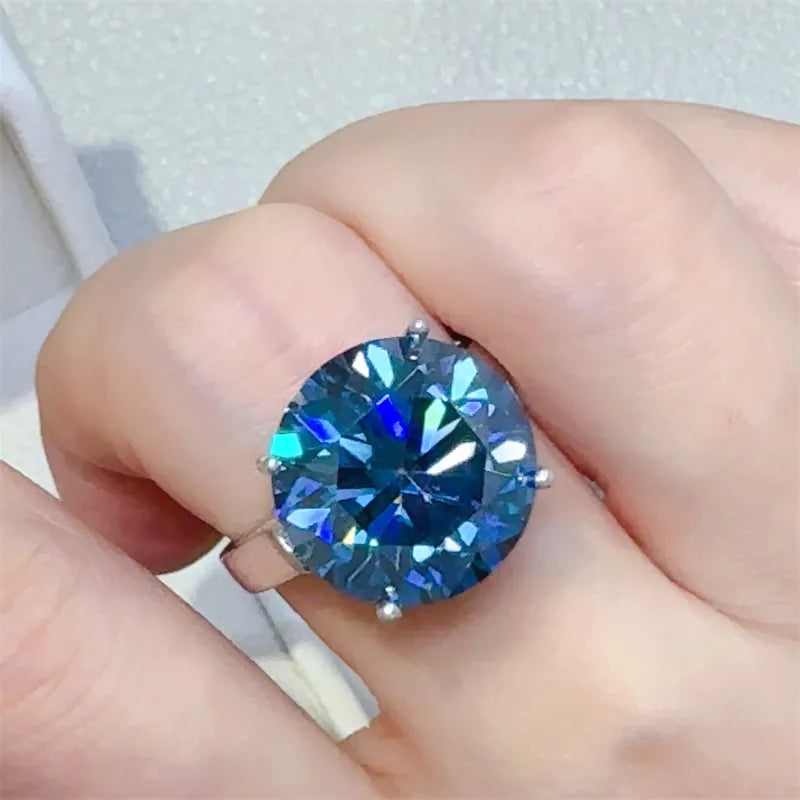 Silver ring with a large, round, bright blue moissanite gemstone.
