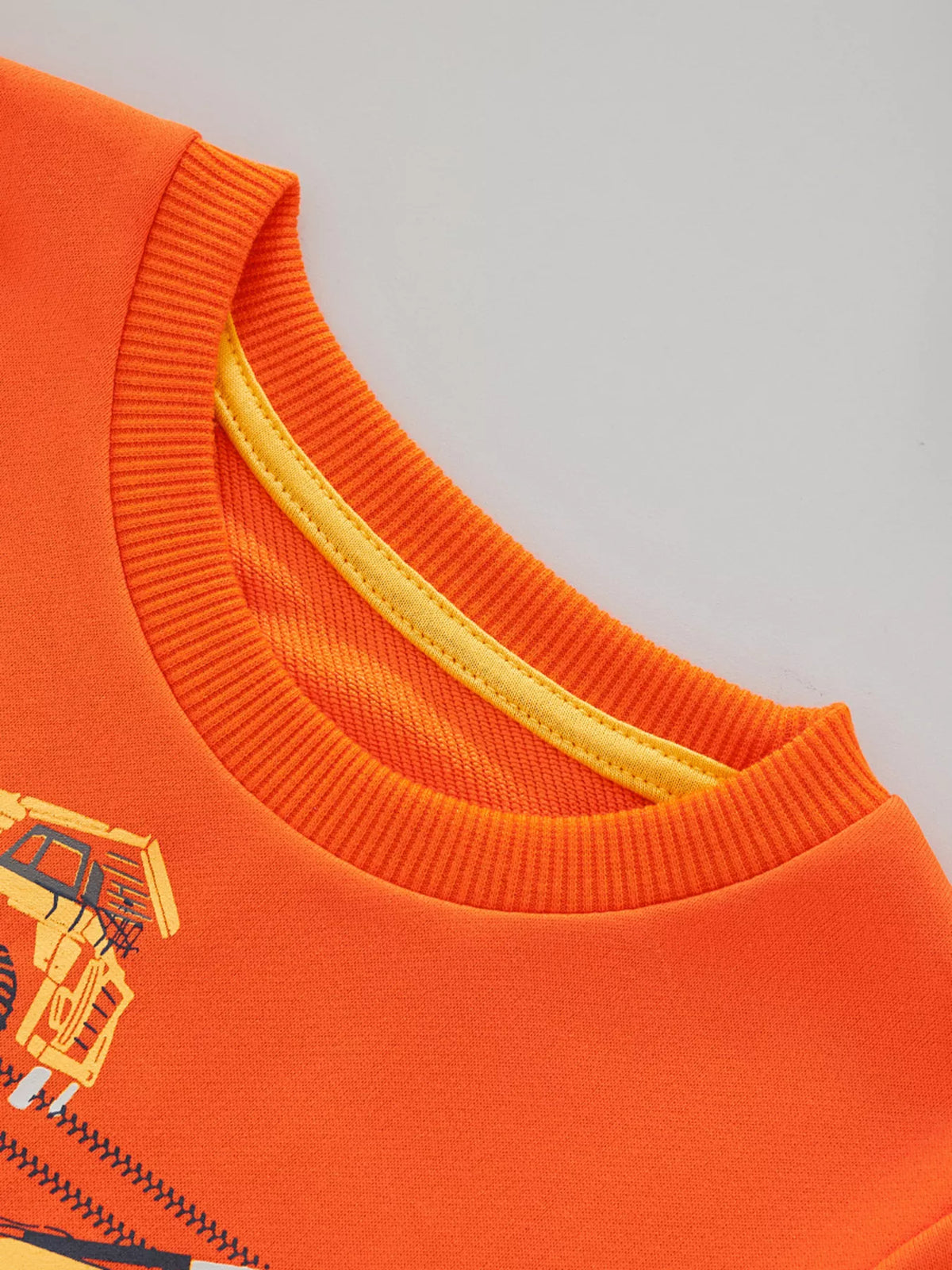 Orange children's sweatshirt with construction vehicle graphic and yellow neck trim.
