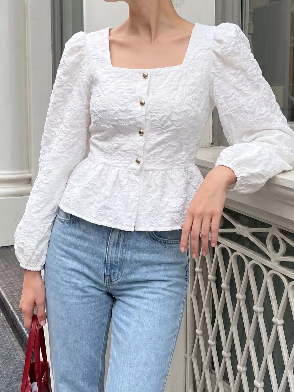 White peplum top featuring buttoned and textured