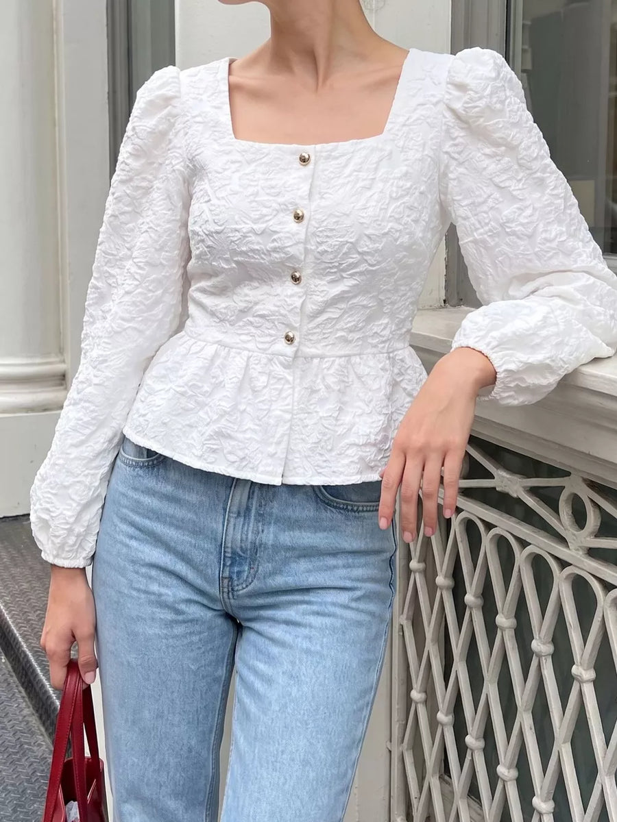 White peplum top featuring buttoned and textured